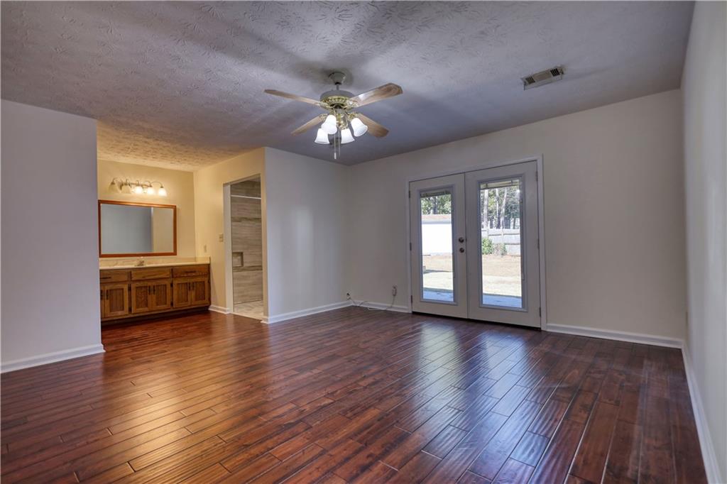 5113 Brownlee Road Southwest Lilburn, GA 30047 - Photo 31 of 48 a view of an empty room with a window and wooden floor