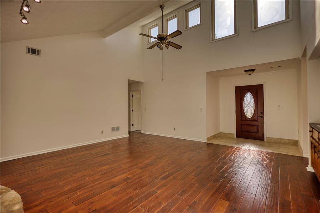 5113 Brownlee Road Southwest Lilburn, GA 30047 - Photo 5 of 48 an empty room with wooden floor and windows