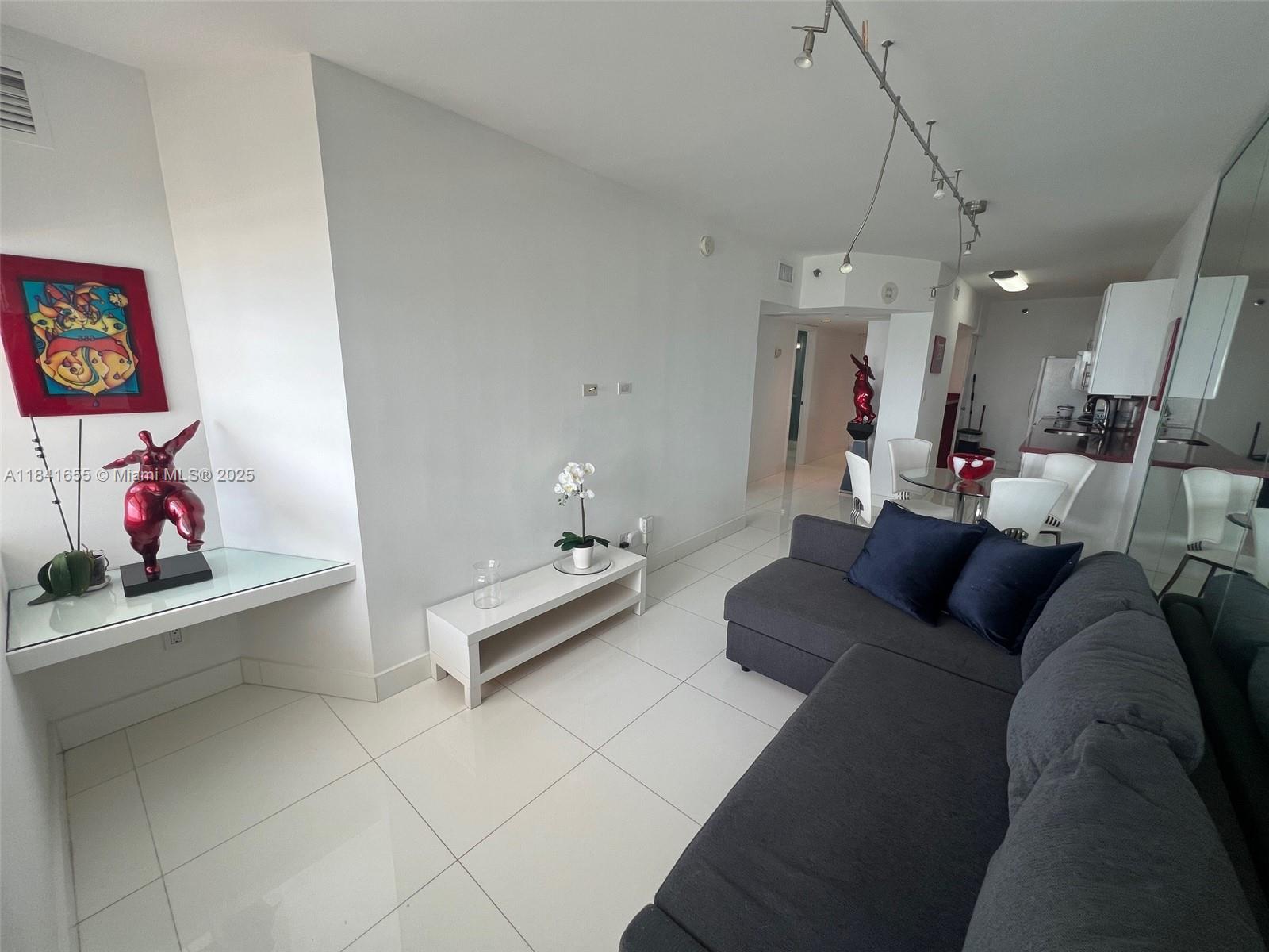 100 Lincoln Road, Unit 1419 Miami Beach, FL 33139 - Photo 12 of 57 a living room with furniture and a chandelier