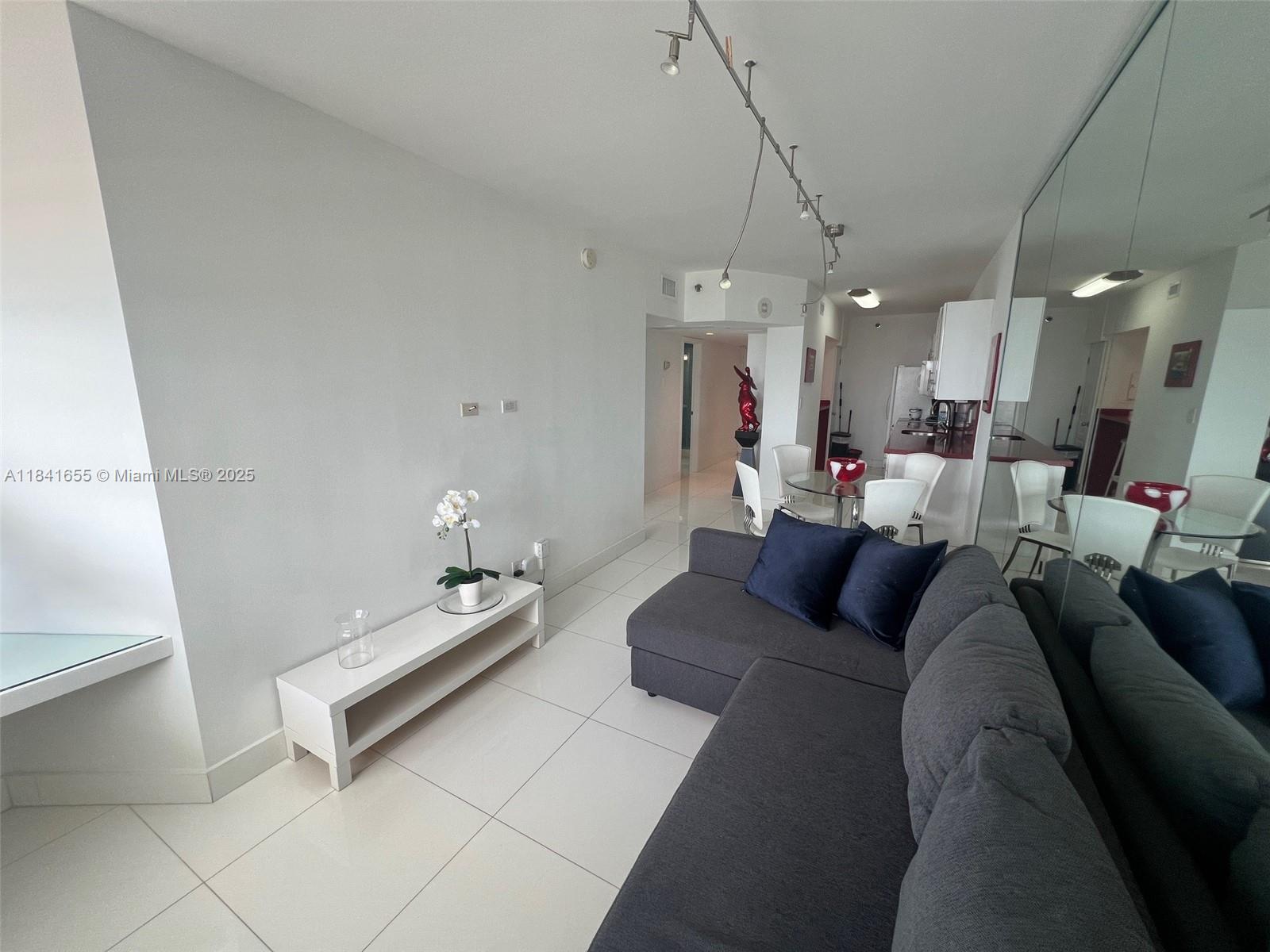 100 Lincoln Road, Unit 1419 Miami Beach, FL 33139 - Photo 13 of 57 a living room with furniture and a chandelier