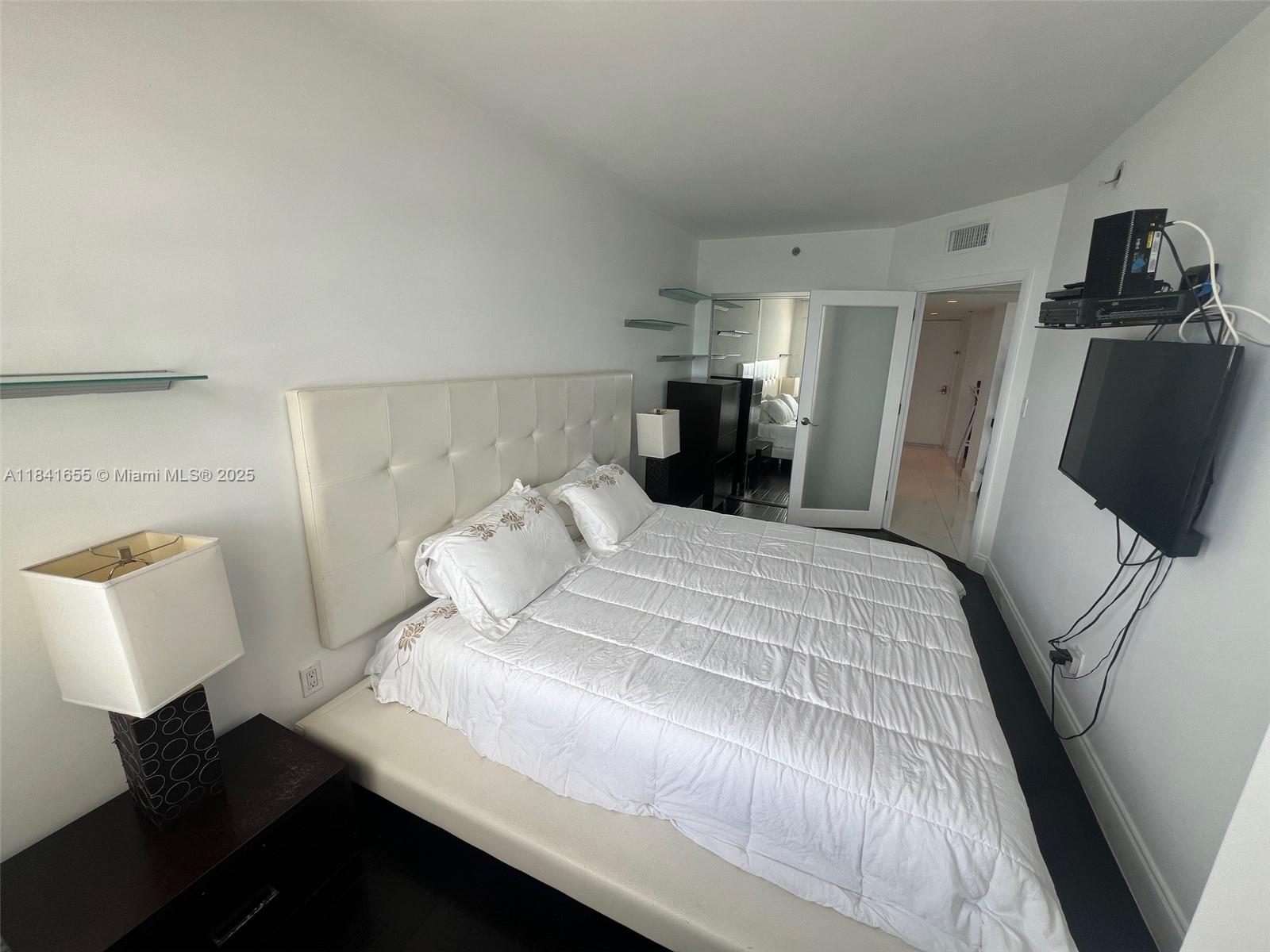 100 Lincoln Road, Unit 1419 Miami Beach, FL 33139 - Photo 15 of 57 a bed room with a bed and a television