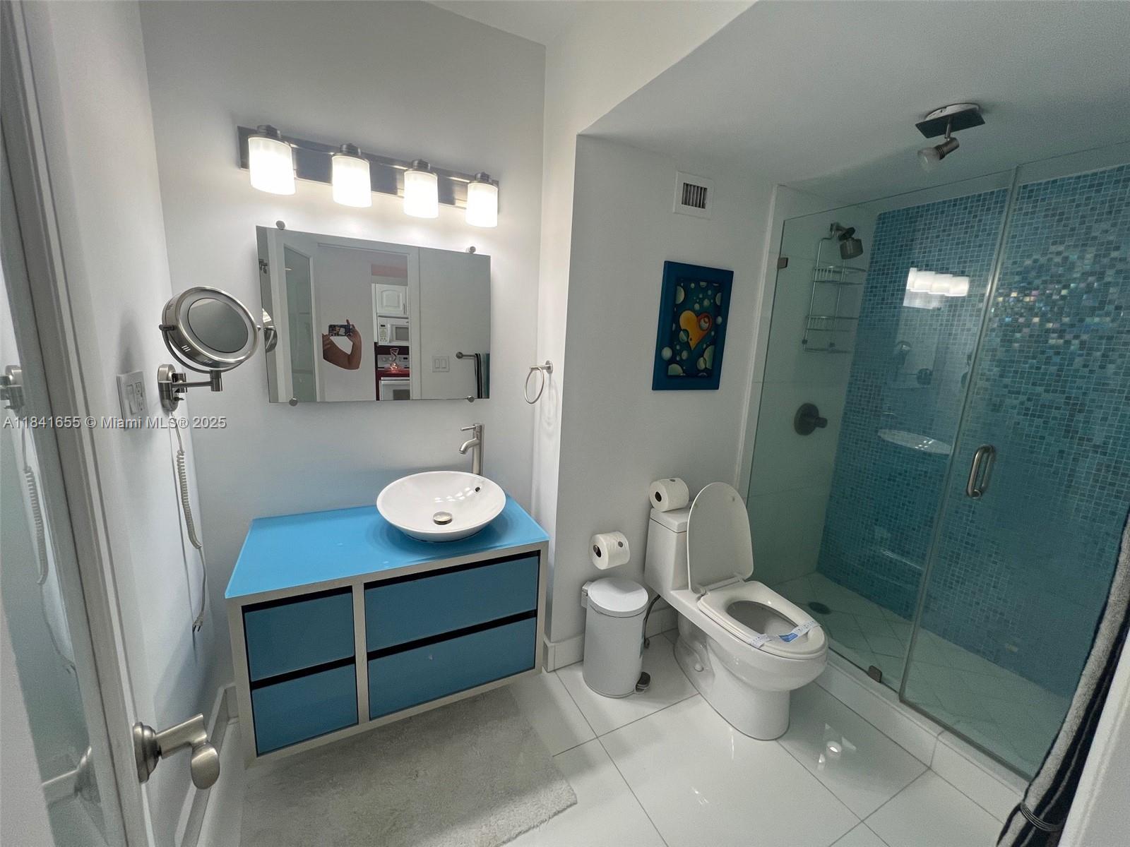 100 Lincoln Road, Unit 1419 Miami Beach, FL 33139 - Photo 17 of 57 a bathroom with a toilet a sink and mirror