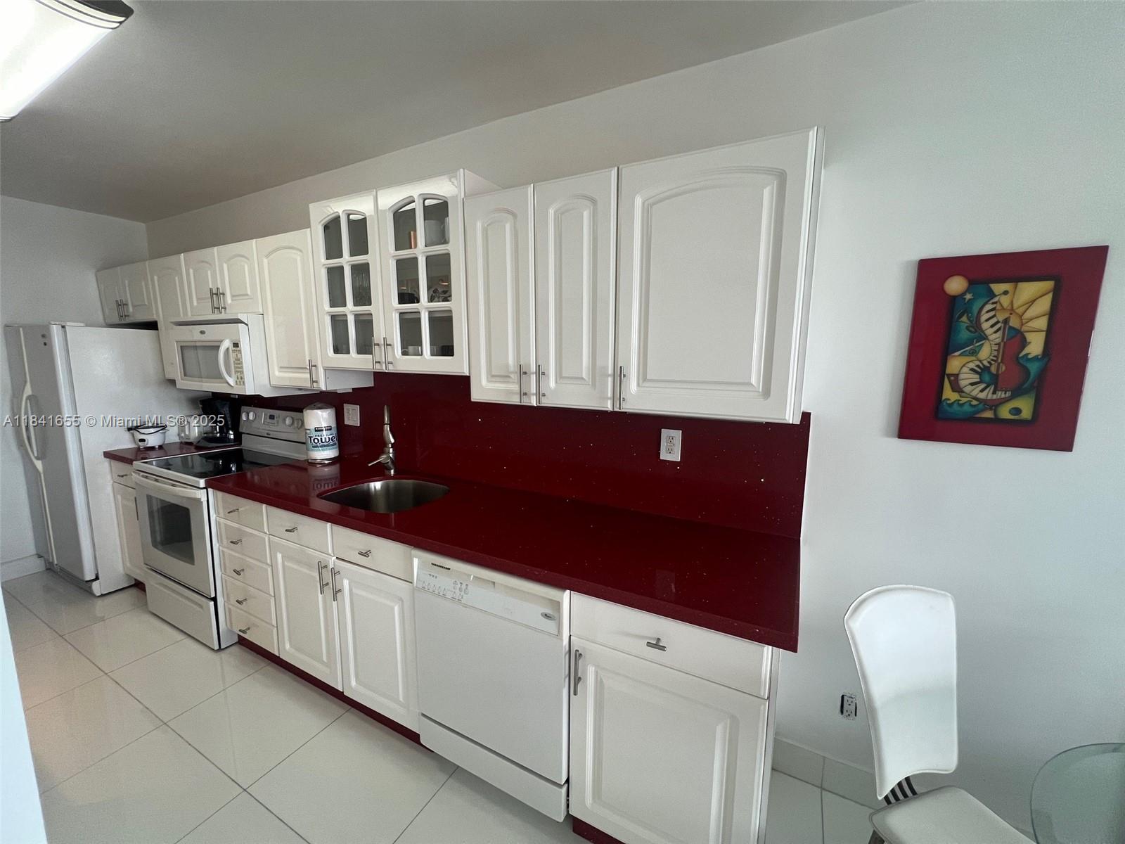 100 Lincoln Road, Unit 1419 Miami Beach, FL 33139 - Photo 8 of 57 a kitchen with granite countertop a stove a sink and a microwave