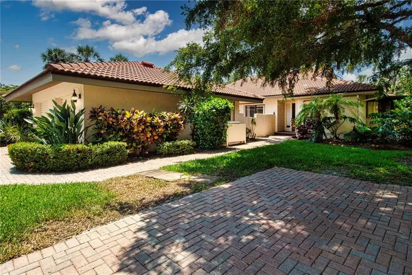 a view of a house with a yard and potted plants