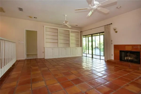 a view of an empty room with a fireplace and a window