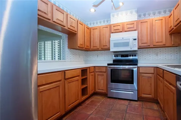 a kitchen with stainless steel appliances granite countertop a sink stove and cabinets