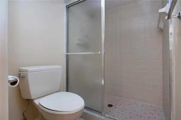 a white toilet sitting next to a shower