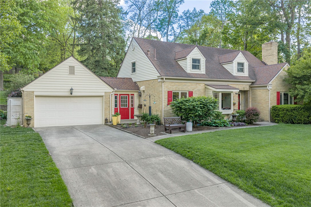 156 West Hadley Road Dayton, OH 45419 - Photo 58 of 71 This charming residence features a well-maintained driveway leading to an attached garage and a vibrant red entry door.