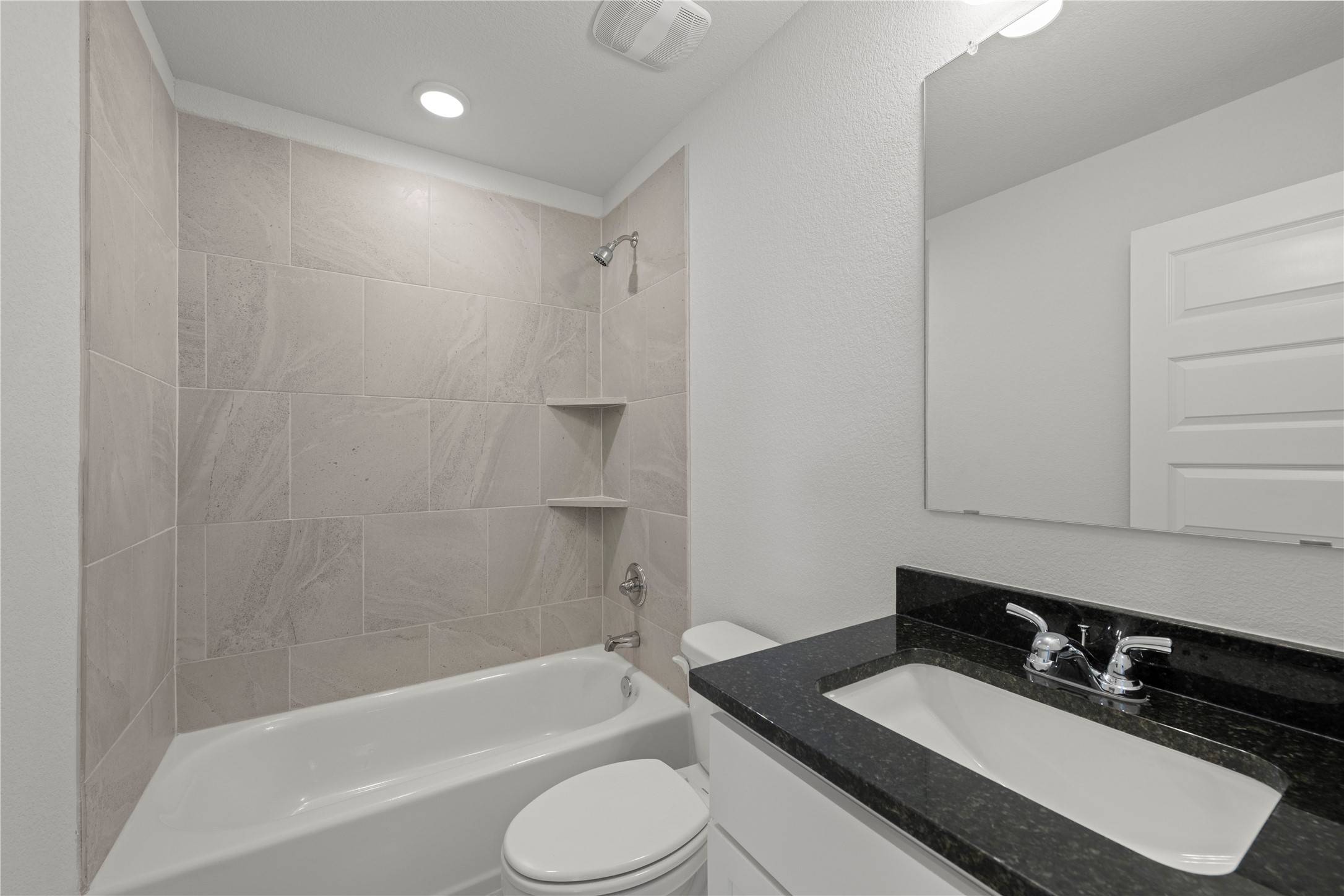 220 Gus Loop Georgetown, TX 78626 - Photo 8 of 18 A well-appointed bath features a tiled shower/tub combination and a modern vanity with integrated sink.