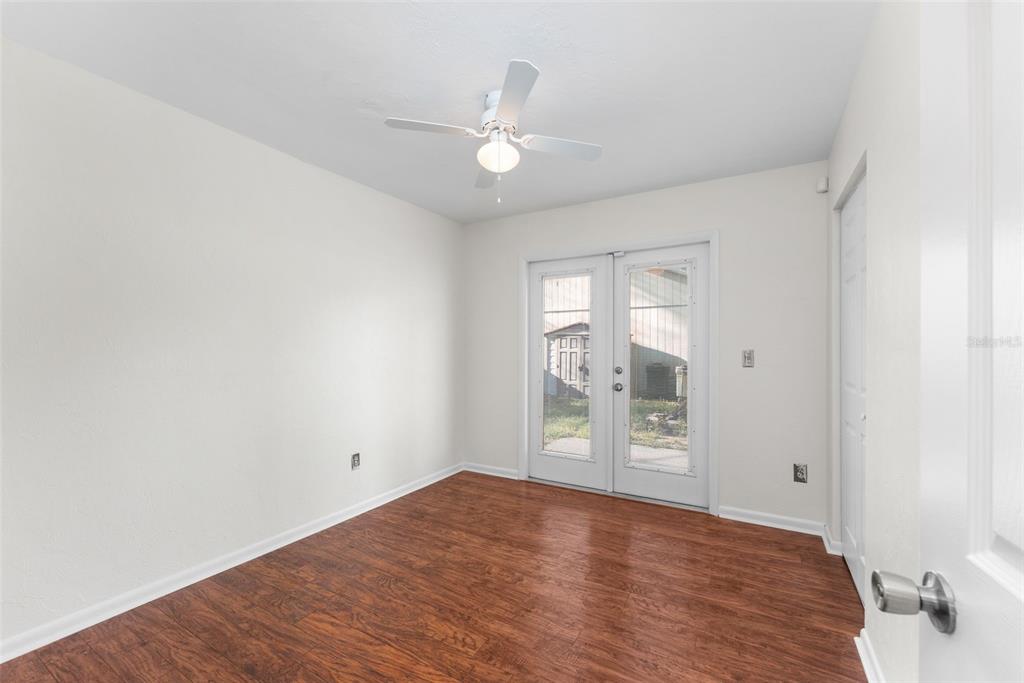 2026 Southwest 73rd Street Gainesville, FL 32607 - Photo 15 of 20 an empty room with wooden floor cabinet and windows