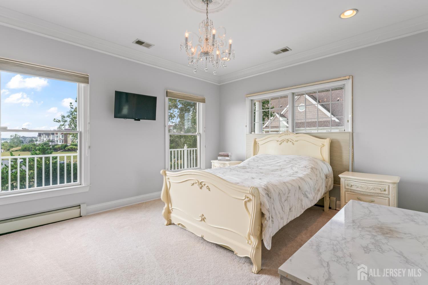 76 Raritan Reach Road South Amboy, NJ 08879 - Photo 54 of 69 a spacious bedroom with a large bed and a chandelier