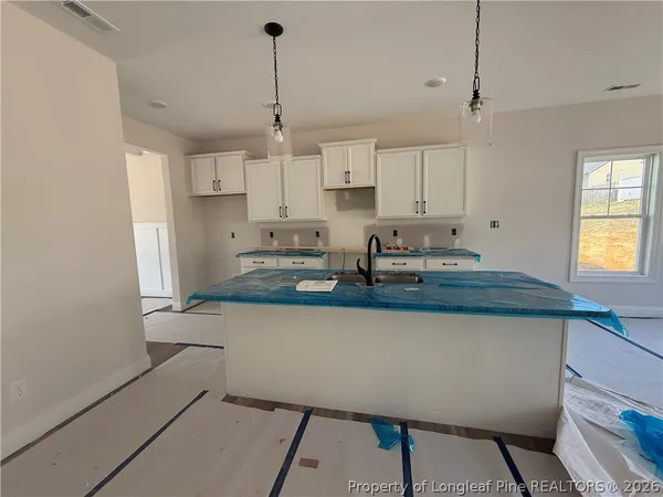 a kitchen with kitchen island a counter top space a sink stainless steel appliances and cabinets