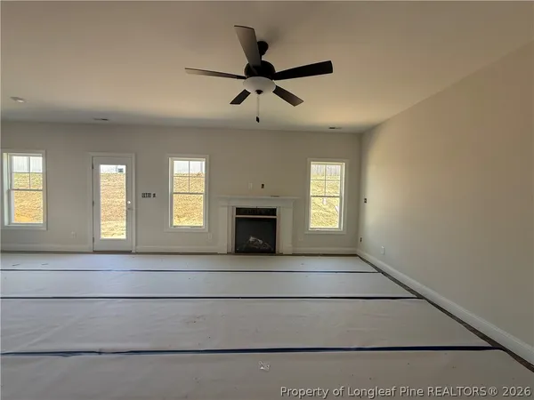 a view of an empty room with a fireplace and a window