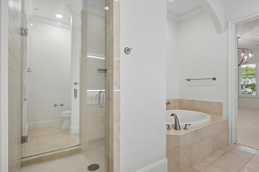 8511 Edgemere Road, Unit 102 Dallas, TX 75225 - Photo 11 of 17 a bathroom with a bathtub and a shower