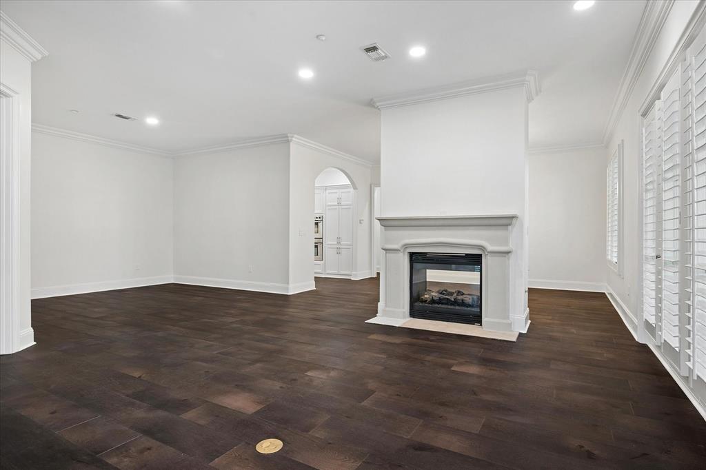 8511 Edgemere Road, Unit 102 Dallas, TX 75225 - Photo 3 of 17 an empty room with wooden floor fireplace and windows