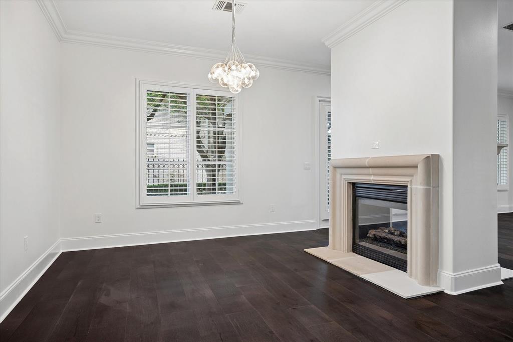 8511 Edgemere Road, Unit 102 Dallas, TX 75225 - Photo 4 of 17 a view of an empty room with wooden floor fireplace and a window