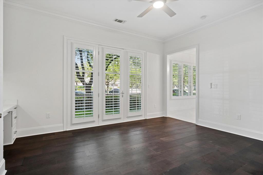 8511 Edgemere Road, Unit 102 Dallas, TX 75225 - Photo 6 of 17 an empty room with wooden floor chandelier fan and windows