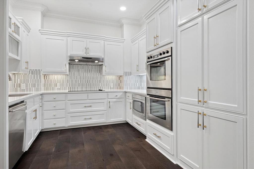 8511 Edgemere Road, Unit 102 Dallas, TX 75225 - Photo 7 of 17 a kitchen with white cabinets and stainless steel appliances