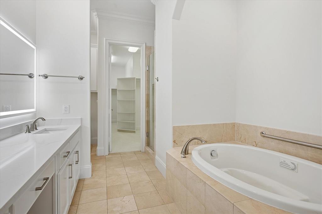 8511 Edgemere Road, Unit 102 Dallas, TX 75225 - Photo 10 of 17 a bathroom with a tub sink and mirror