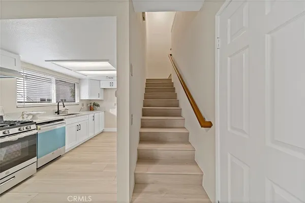 a large white kitchen with stainless steel appliances granite countertop a stove and a sink