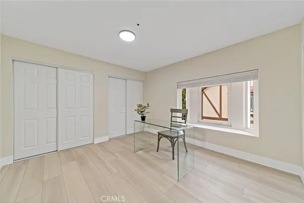 a workspace room with wooden floor and windows
