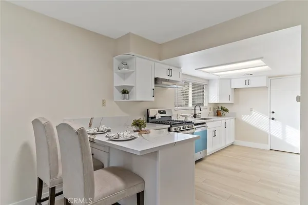 a kitchen with a dining table chairs stove and cabinets