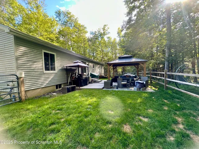 a view of a chair and table in backyard of the house