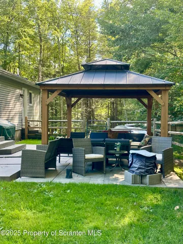 a view of a lake with lawn chairs and a large tree