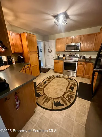a kitchen with sink a refrigerator and chairs