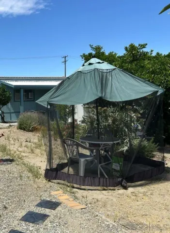 a patio with table and chairs under an umbrella