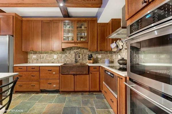 a kitchen with stainless steel appliances kitchen island granite countertop a table chairs in it and wooden floors