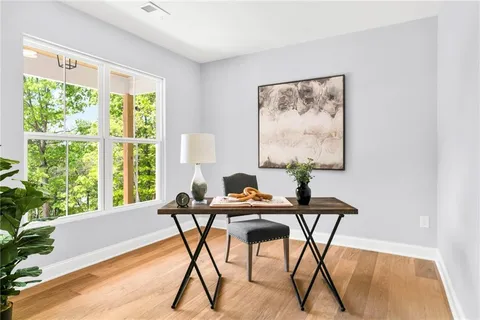 a view of a workspace room with furniture and a window
