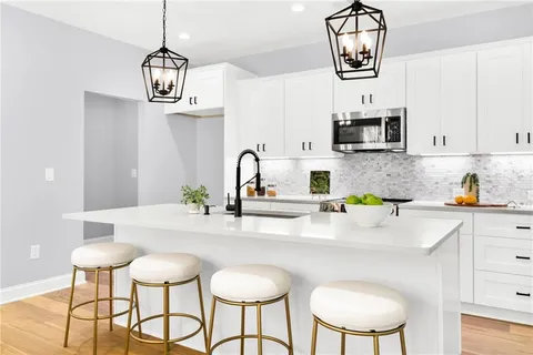 a kitchen with stainless steel appliances a sink cabinets and wooden floor