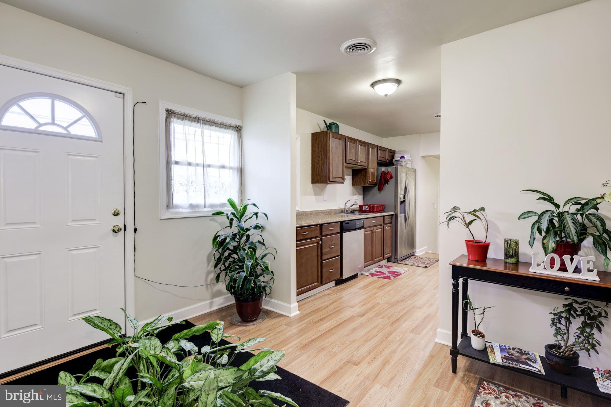 5905 Johnnycake Road Baltimore, MD 21228 - Photo 3 of 30 a living room with kitchen island a potted plant and a wooden floor