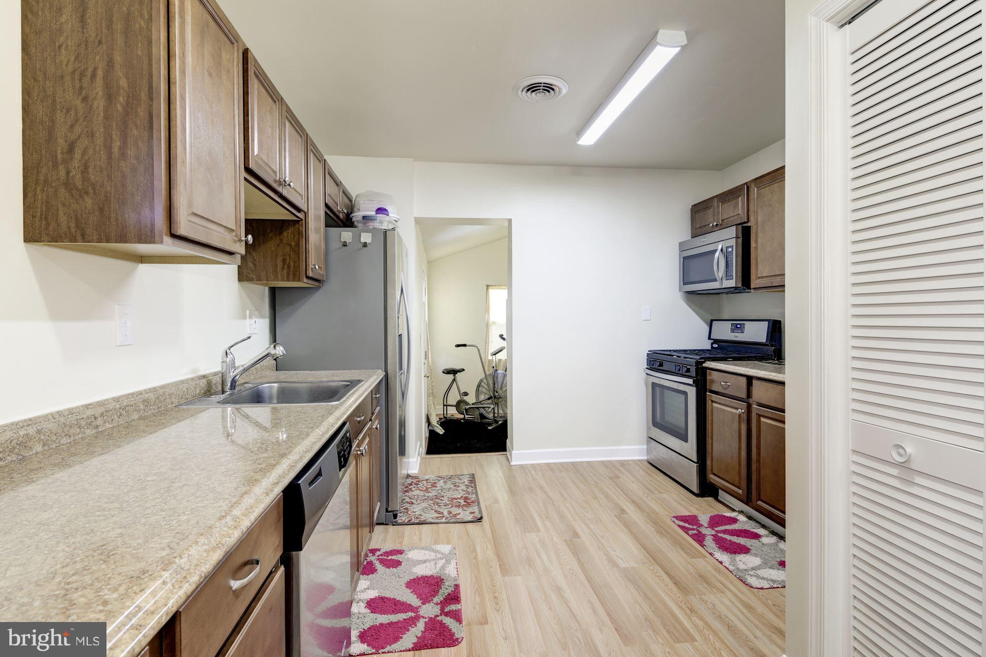 5905 Johnnycake Road Baltimore, MD 21228 - Photo 6 of 30 a kitchen with granite countertop a sink stove and refrigerator