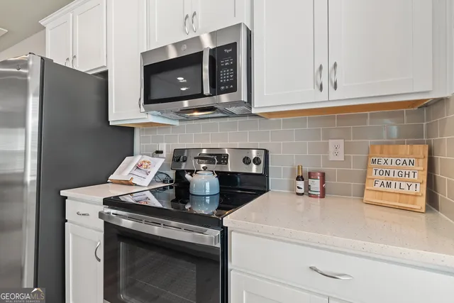a kitchen with stainless steel appliances granite countertop a sink stove and microwave