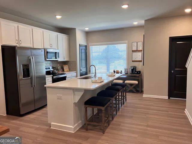 a kitchen with sink a refrigerator and cabinets