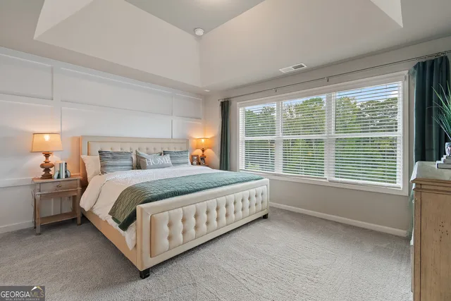 a bed sitting in a spacious bedroom next to a window