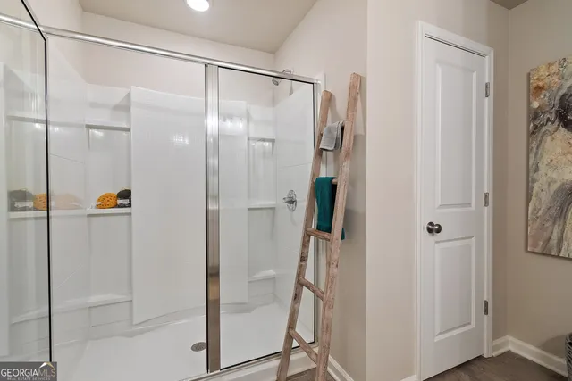 a bathroom with a glass shower door and a glass door