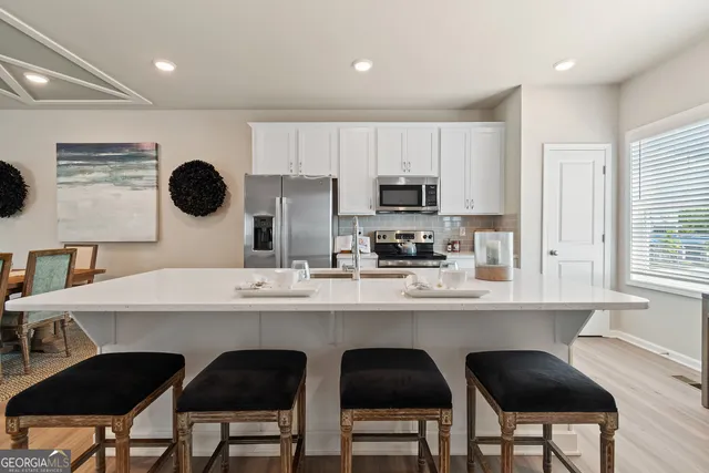 a kitchen with a dining table chairs and a refrigerator