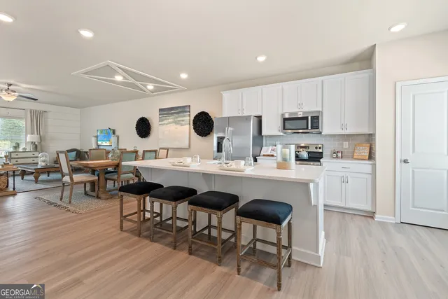 a living room with stainless steel appliances kitchen island granite countertop furniture and wooden floor