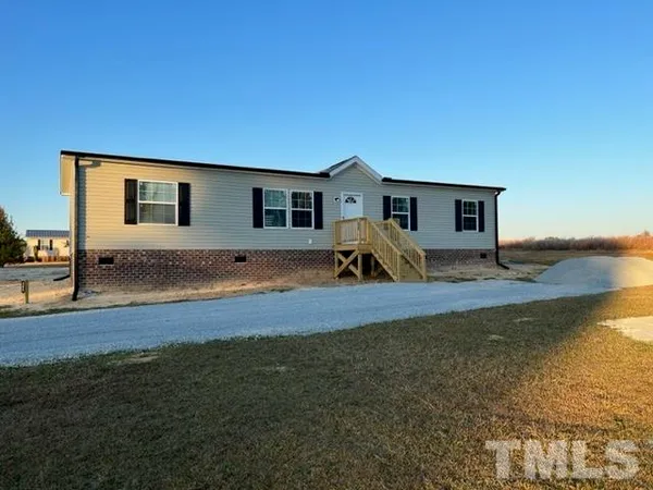 a view of a house with backyard and trees