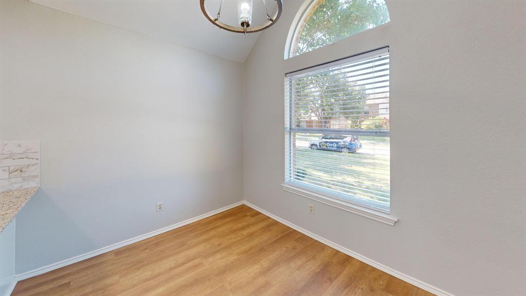 7913 Rice Drive Rowlett, TX 75088 - Photo 11 of 25 Dining area featuring wood-finish flooring, a large window with blinds, and an arched transom window