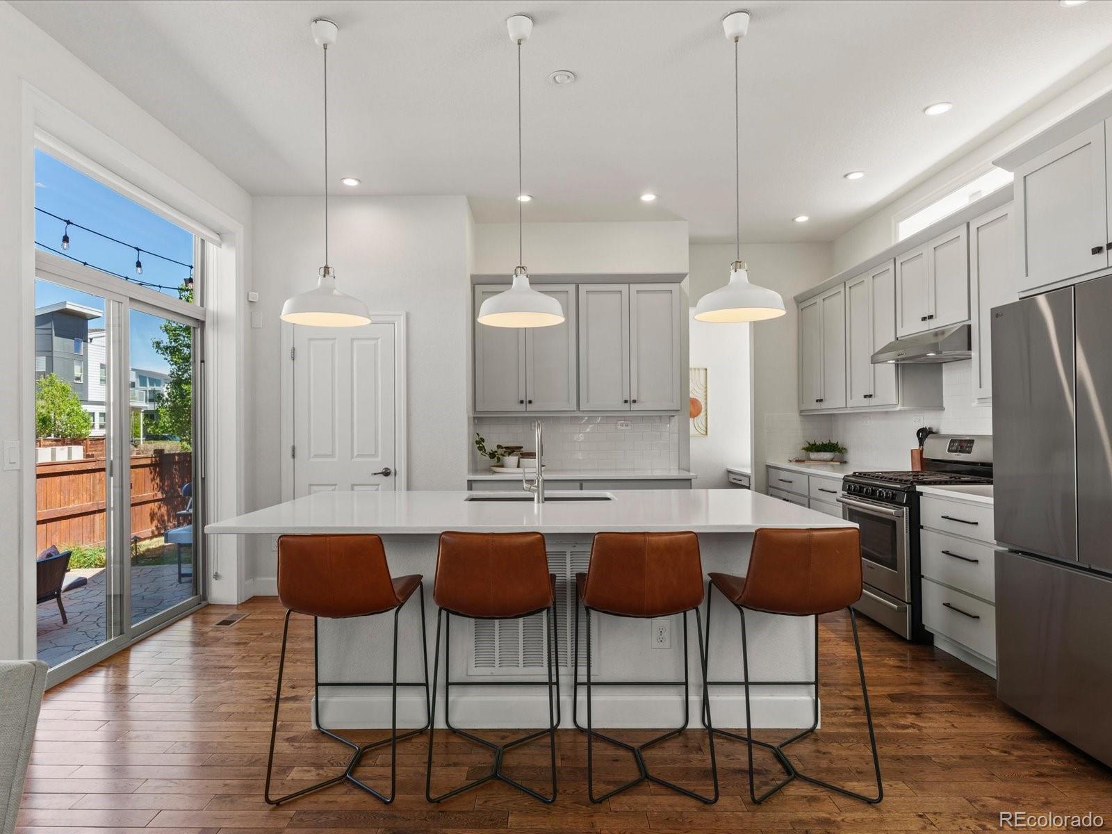 5446 Uinta Way Denver, CO 80238 - Photo 11 of 49 a kitchen with stainless steel appliances kitchen island a table and chairs in it