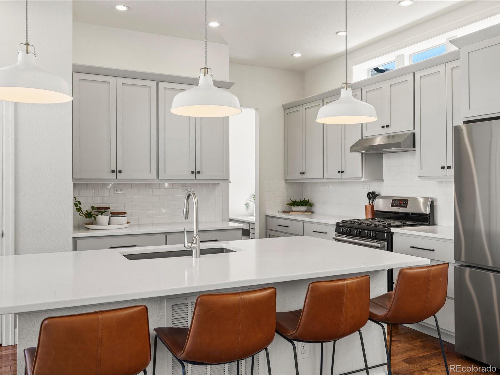 5446 Uinta Way Denver, CO 80238 - Photo 12 of 49 a kitchen with stainless steel appliances granite countertop a sink a stove a refrigerator and chairs