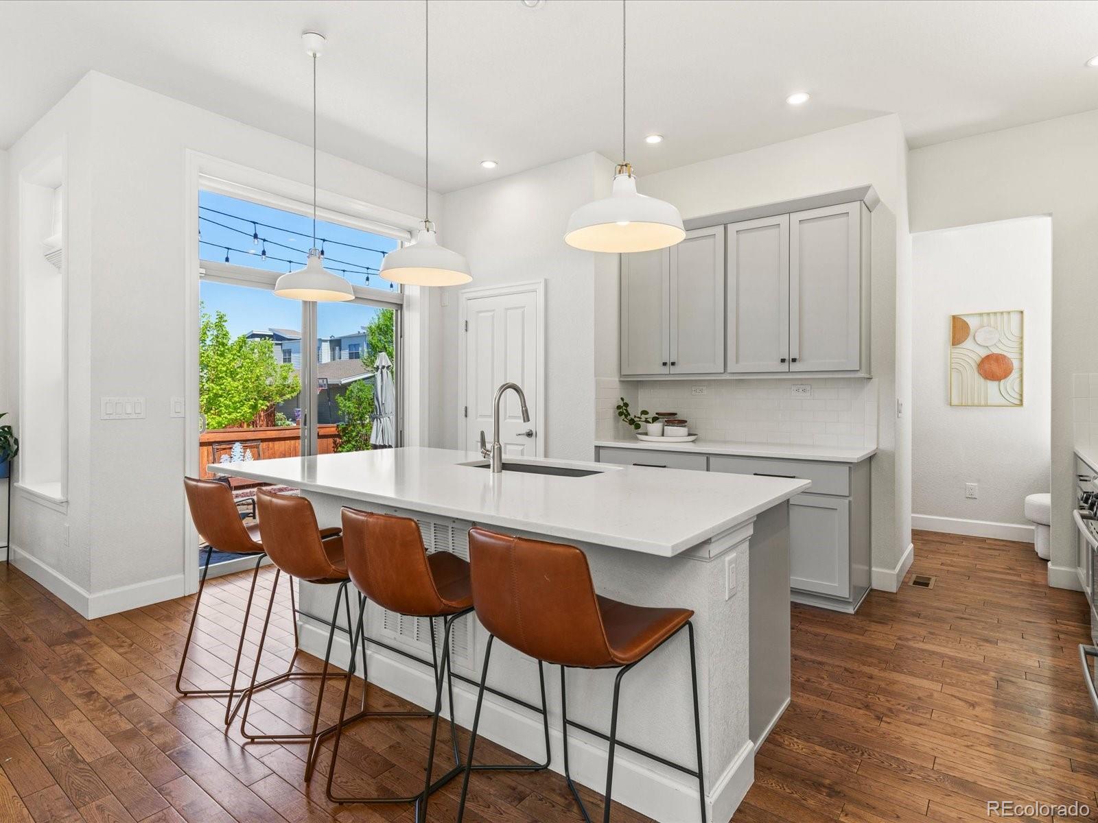5446 Uinta Way Denver, CO 80238 - Photo 13 of 49 a kitchen with stainless steel appliances a dining table chairs and wooden floor