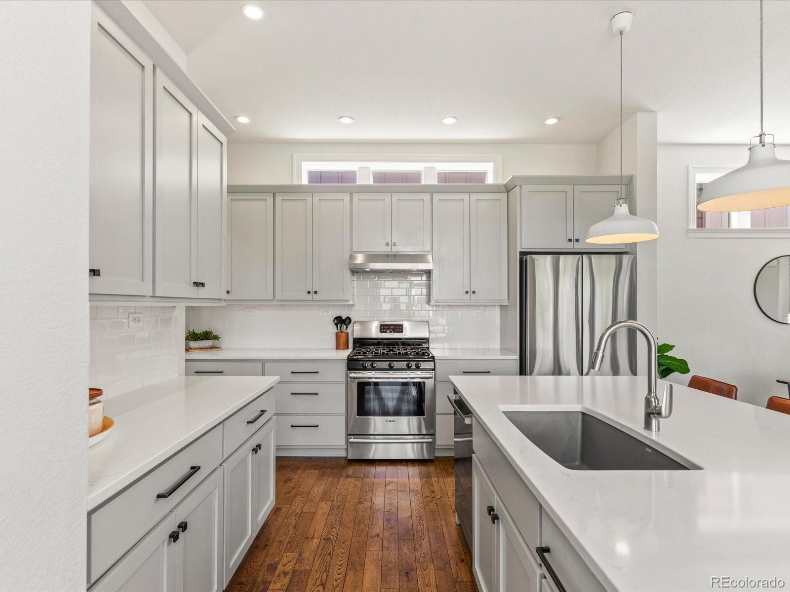 5446 Uinta Way Denver, CO 80238 - Photo 15 of 49 a kitchen with kitchen island white cabinets and stainless steel appliances