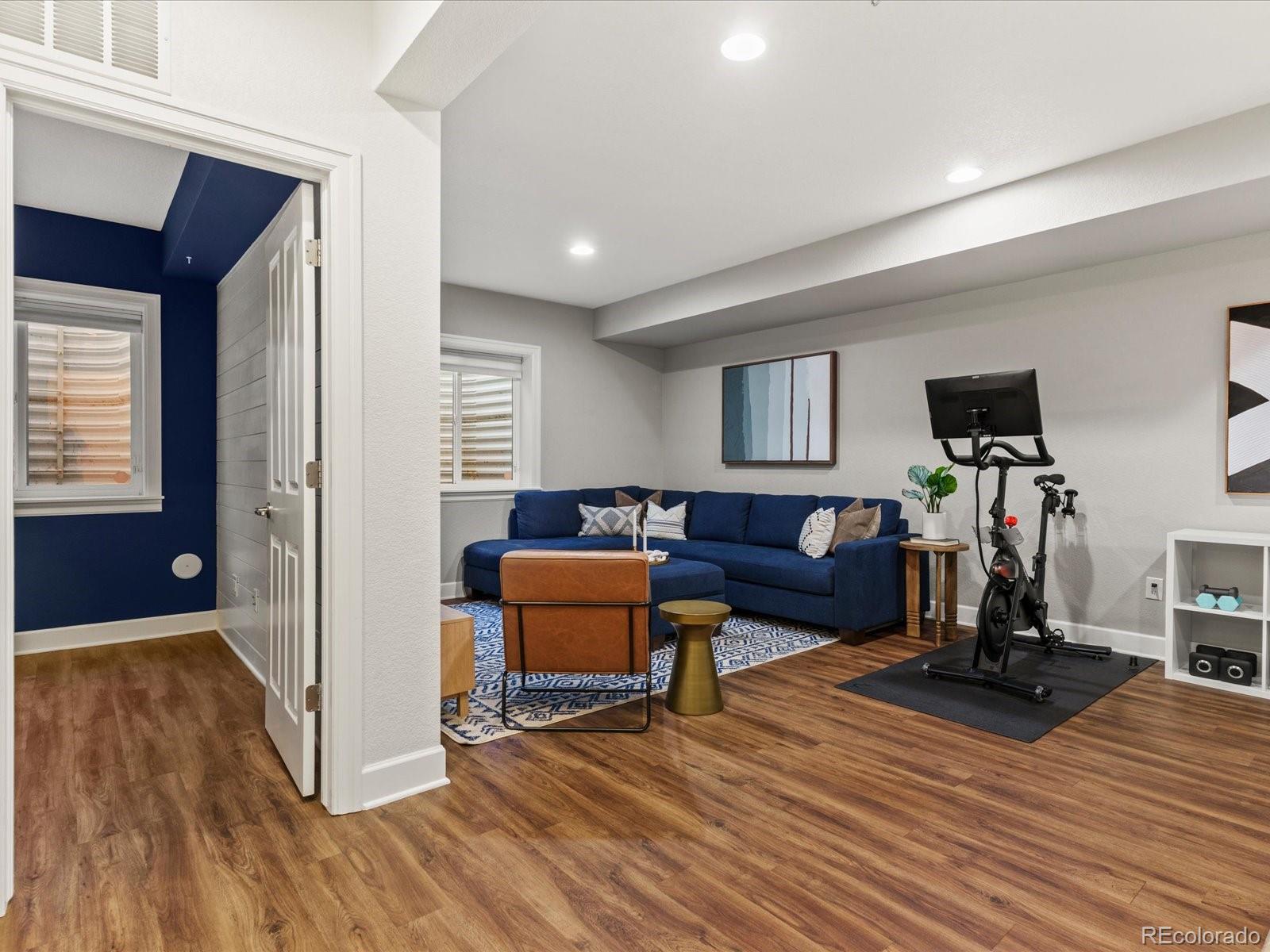 5446 Uinta Way Denver, CO 80238 - Photo 35 of 49 a living room with furniture a flat screen tv and a wooden floor