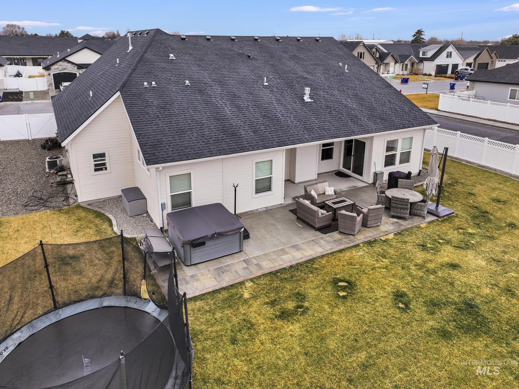 3103 Moonrise Road Twin Falls, ID 83301 - Photo 36 of 40 Back of property featuring outdoor furniture, a residential view, a patio area, a fenced backyard, and a trampoline