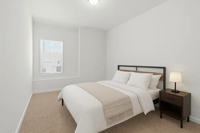 a bedroom with a bed and a painting on the wall